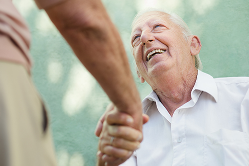 Elderly man looking up and doctor shaking his hand